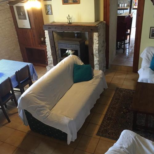 a couch in a living room with a fireplace at La Vendange Family Gites in Gibourne