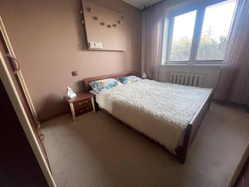 a small bedroom with a bed and a window at VIP Apartment Kolorowa in Rzeszów