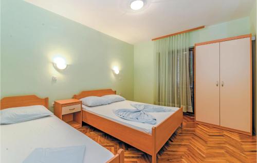 a bedroom with two beds and a closet at 2 Bedroom Gorgeous Apartment In Bosana in Stan Trigraci