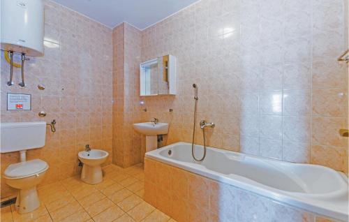 a bathroom with a tub and a toilet and a sink at 2 Bedroom Gorgeous Apartment In Bosana in Stan Trigraci