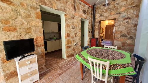 a dining room with a table and a tv at B&B Nuraximannu in Santadi