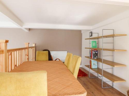 a room with a table and chairs and shelves at Asquith Penthouse in Huddersfield