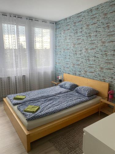 ein Schlafzimmer mit einem Bett und einer Ziegelwand in der Unterkunft Dózsa Apartman in Gödöllő