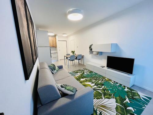 uma sala de estar com um sofá e uma televisão de ecrã plano em Kristall Lago Residence em Desenzano del Garda
