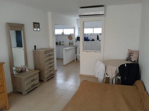 a living room with a table and a kitchen at Отдельная квартира в 15 минутах от моря in Ashdod