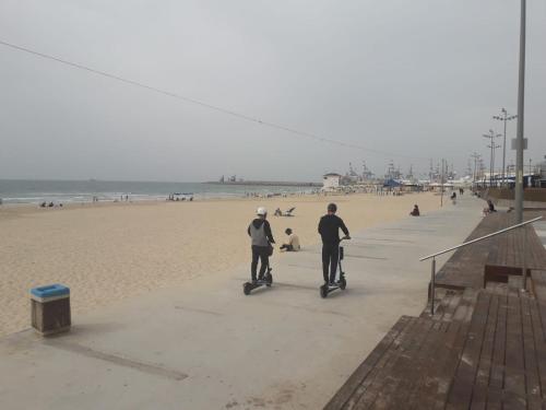 two people riding on scooters on the beach at Отдельная квартира в 15 минутах от моря in Ashdod