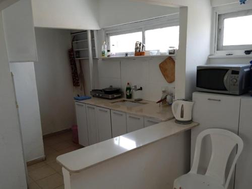 a small kitchen with a counter and a microwave at Отдельная квартира в 15 минутах от моря in Ashdod