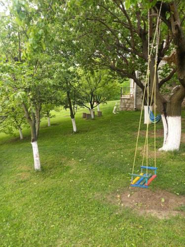 a swing in a park with trees and grass at Guest house Ijevan's Garden in Ijevan