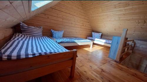 a room with two beds and a bench in a attic at Słoneczne Zacisze in Smołdziński Las