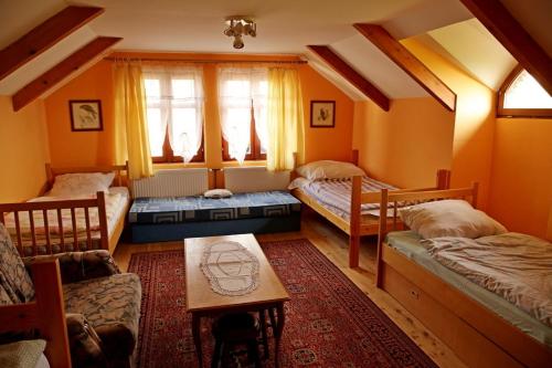 a room with two beds and a table in it at Magdi vendégház in Šupljak
