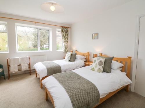 two beds in a room with two windows at Loose Hill Lea in Bamford