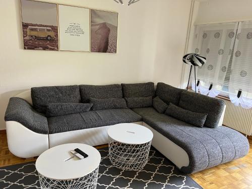 a living room with a couch and two tables at MYM NOW Apartment in Bern in Bern