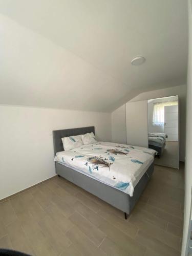 1 dormitorio con cama y espejo en Apartman Žepče, en Žepče