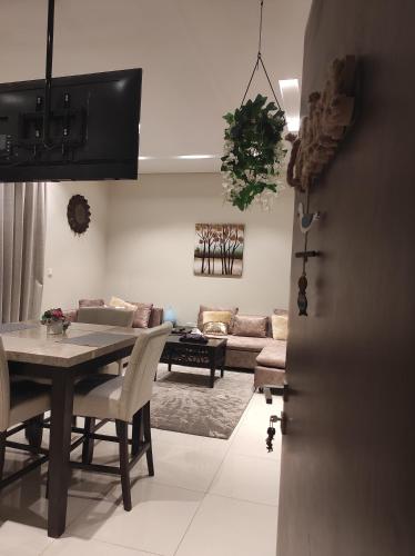 a living room with a table and a couch at Segal Salalah-Forest Island-Hawana in Salalah