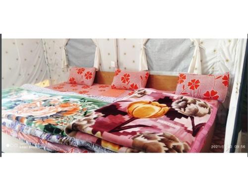 a bed with a blanket and pillows on it at Shivalik Camping & Cottage, Joshimath in Joshīmath