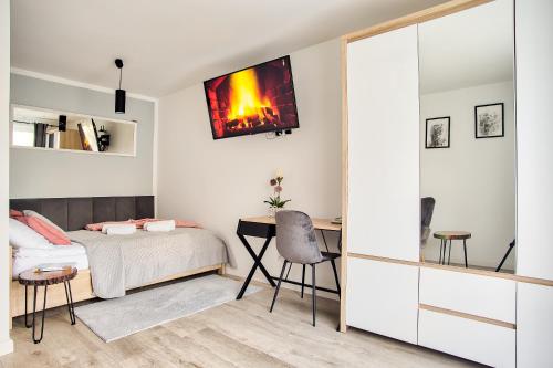 Schlafzimmer mit einem Bett und einem Schreibtisch mit einem TV an der Wand in der Unterkunft Apartament Dla Dwojga in Sanok