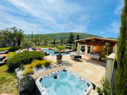 a backyard with a hot tub in a yard at La Bastide des Bourguets, Mont Ventoux - Adults Only in Sault-de-Vaucluse