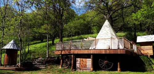 CambounèsにあるLe tipi à Marie, déconnectez- vous !!!の屋根付きの森の木造家屋