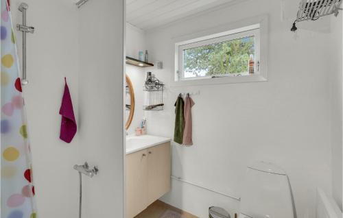 un bagno bianco con lavandino e finestra di 2 Bedroom Pet Friendly Home In Stege a Stege