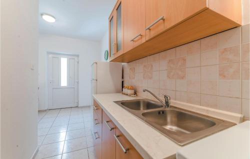 a kitchen with a sink and a refrigerator at Cozy Apartment In Bosana With Kitchen in Stan Trigraci
