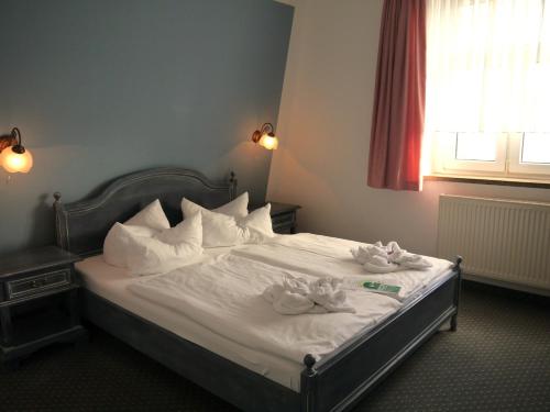a bedroom with a bed with two towels on it at Hotel Esplanade Garni in Kühlungsborn