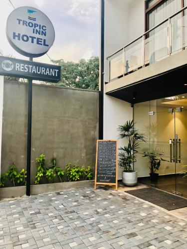 a sign in front of a building with a hotel at Tropic Inn - Mount Lavinia in Mount Lavinia