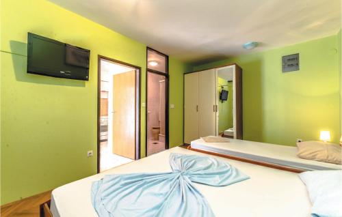 a bedroom with two beds and a tv on the wall at Beautiful Apartment In Bosana With Wifi in Stan Trigraci