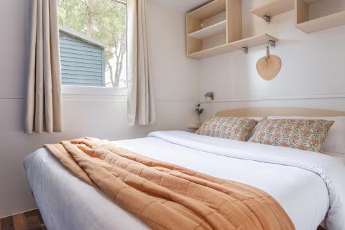 een slaapkamer met een bed met een deken erop bij Bungalows Tia Polly & Indiana Jones & Yoko Ono in L'Escala