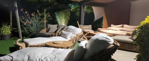 patio z wiklinowymi krzesłami i stołem z poduszkami w obiekcie Chambre d'hôtes Casa Lucia w mieście Furiani