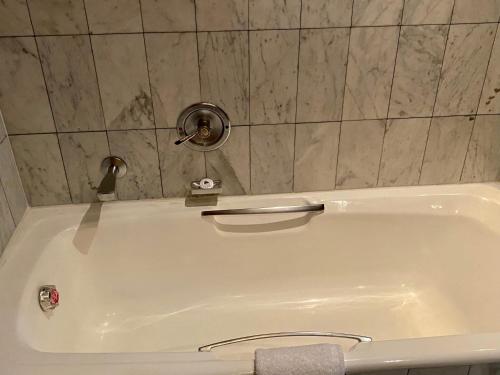 a white bath tub with a faucet in a bathroom at The Royal Hotel by Coastlands Hotels & Resorts in Durban