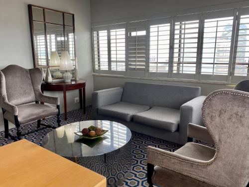 a living room with a couch and chairs and a table at The Royal Hotel by Coastlands Hotels & Resorts in Durban