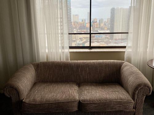 a couch sitting in front of a large window at The Royal Hotel by Coastlands Hotels & Resorts in Durban