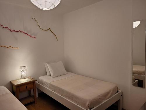 a small room with two beds and a lamp at Coloured Studio in Faro