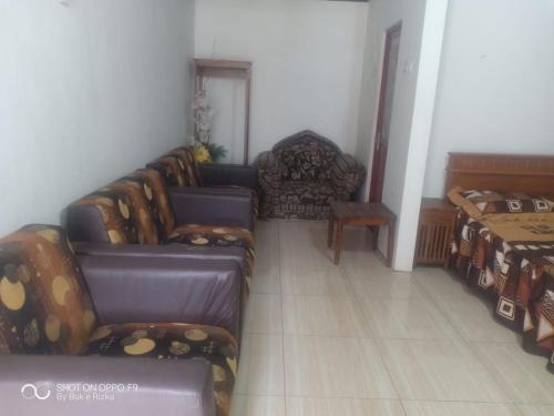 a living room with couches and chairs in a room at Warung Rizka in Probolinggo