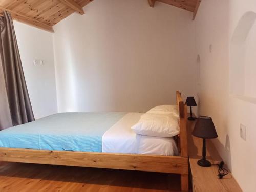 a bedroom with a wooden bed in a room at Aloni Cottage above Aegean Sea in Raches