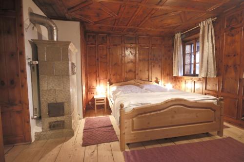 a bedroom with a bed and a fireplace in it at Finhäusl - Urlaub bei Oma in Aldino