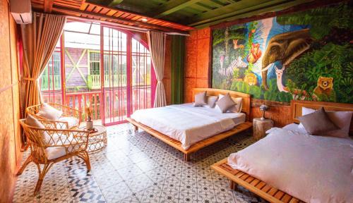 a bedroom with two beds and a painting on the wall at Auguri Homestay Mang Den in Kon Von Kla