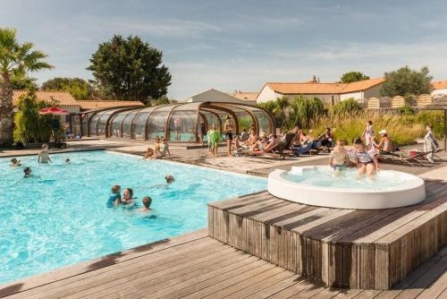 un groupe de personnes dans une piscine d'un complexe hôtelier dans l'établissement Camping Le Village de la Mer, à Les Moutiers