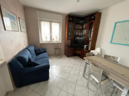 een woonkamer met een blauwe bank en een tafel bij Comodo alloggio in Beinette - Casa Allegri in Beinette