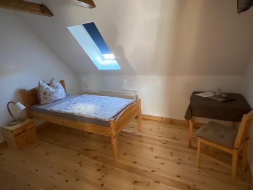 a small room with a bed and a skylight at Pension Landhaus an der Saale in Bernburg