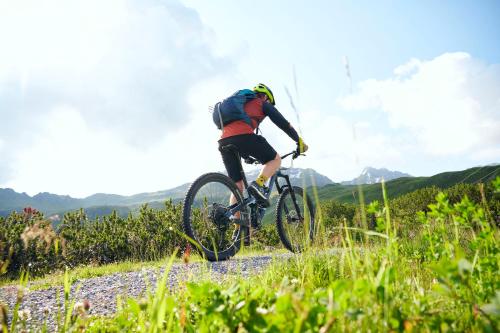 a person riding a bike on a dirt road at Alpine Lodge Klösterle am Arlberg in Klösterle am Arlberg
