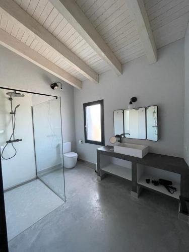 uma casa de banho com uma cabina de duche em vidro e um lavatório. em Casa Palma Pals 2 em Pals