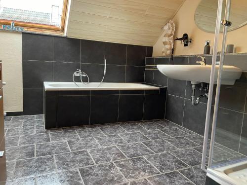 ein Badezimmer mit einem Waschbecken, einer Badewanne und einem Waschbecken in der Unterkunft Ferienhaus Mone in Monschau