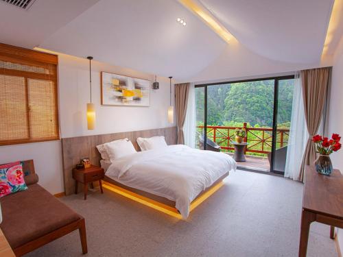 a bedroom with a large bed and a balcony at Mount View Cottage in Zhangjiajie