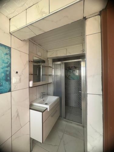 a bathroom with a sink and a shower and a mirror at Erkal Pension in Antalya