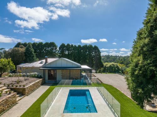 an overhead view of a swimming pool in a garden with a house at Adelaide Hills luxury cottage spectacular views in Summertown