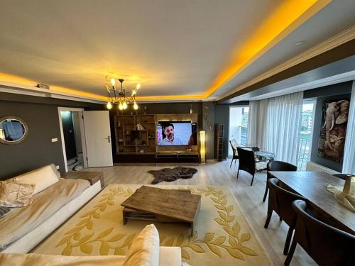 a living room with a couch and a table and a tv at Akhome - Luxury dublex apartment in Canakkale