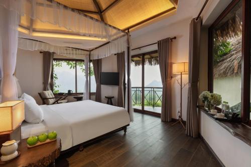 Pu Luong的住宿－EBINO PULUONG RESORT，一间带大床的卧室和一个阳台