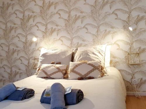 a bedroom with a white bed with blue towels on it at Le Coco Playa - Madame Conciergerie in Bruz
