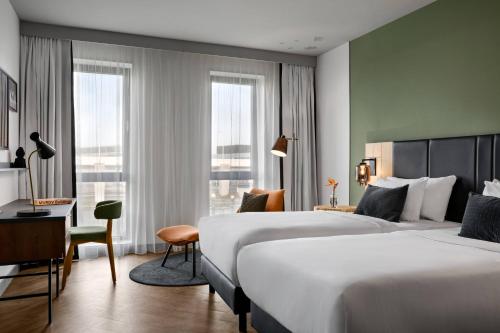 a hotel room with two beds and a desk at Renaissance Amsterdam Schiphol Airport Hotel in Schiphol